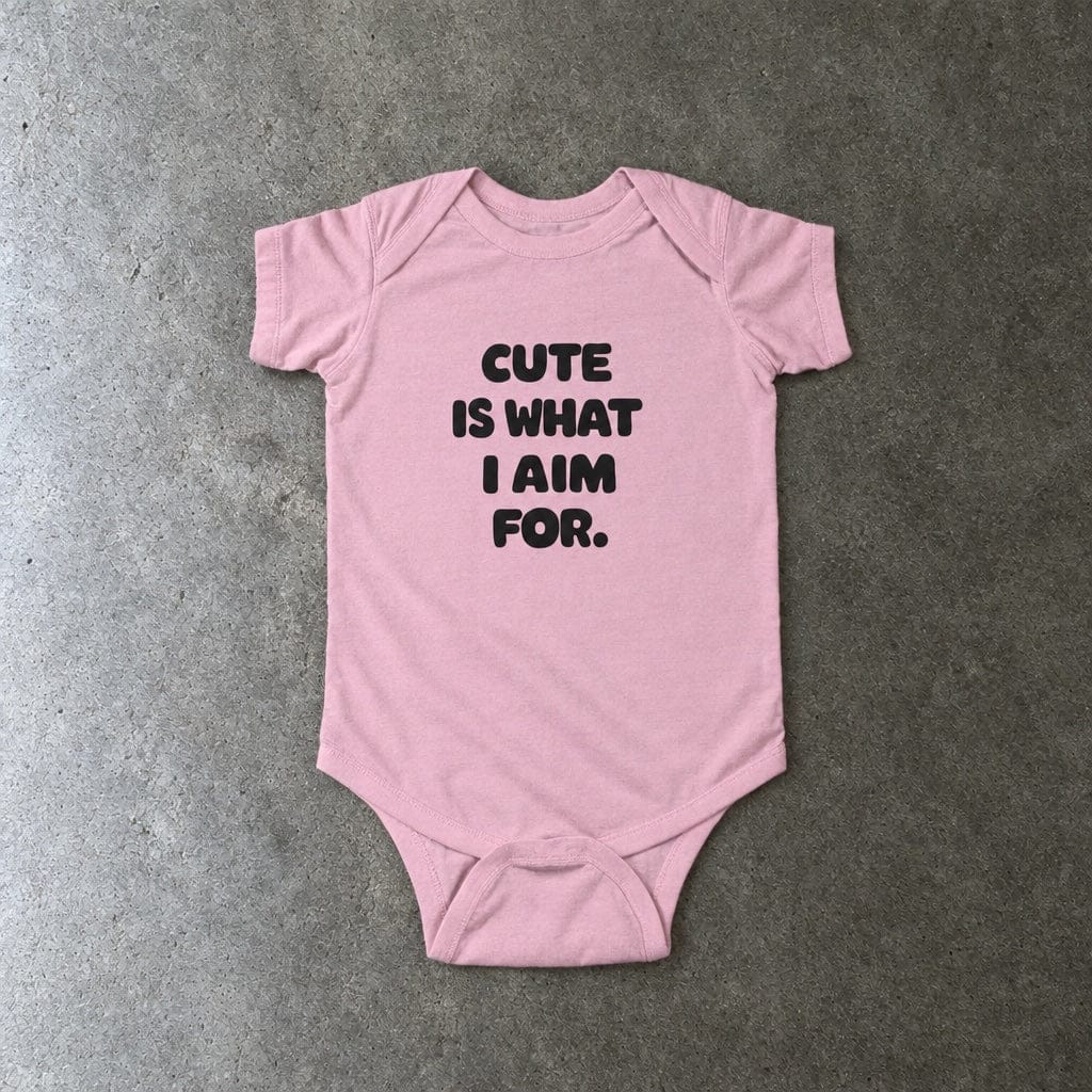 Cute Is What I Aim For onesie in pink, laid flat