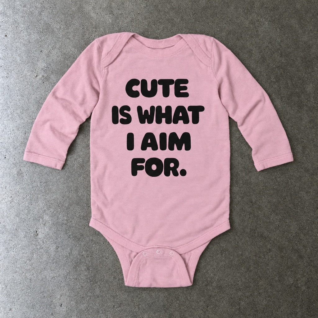 Cute Is What I Aim For long sleeve onesie in pink, laid flat