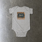 Screaming Infant Melodies onesie in ash, laid flat